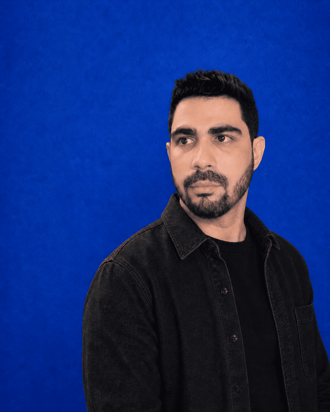 An editorial portrait of Yasiel Cabrera in a black overshirt, looking toward the page content